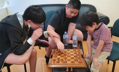 Summer Camp students learning English and playing chess